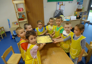 Dzieci z pizzą gotową do pieczenia